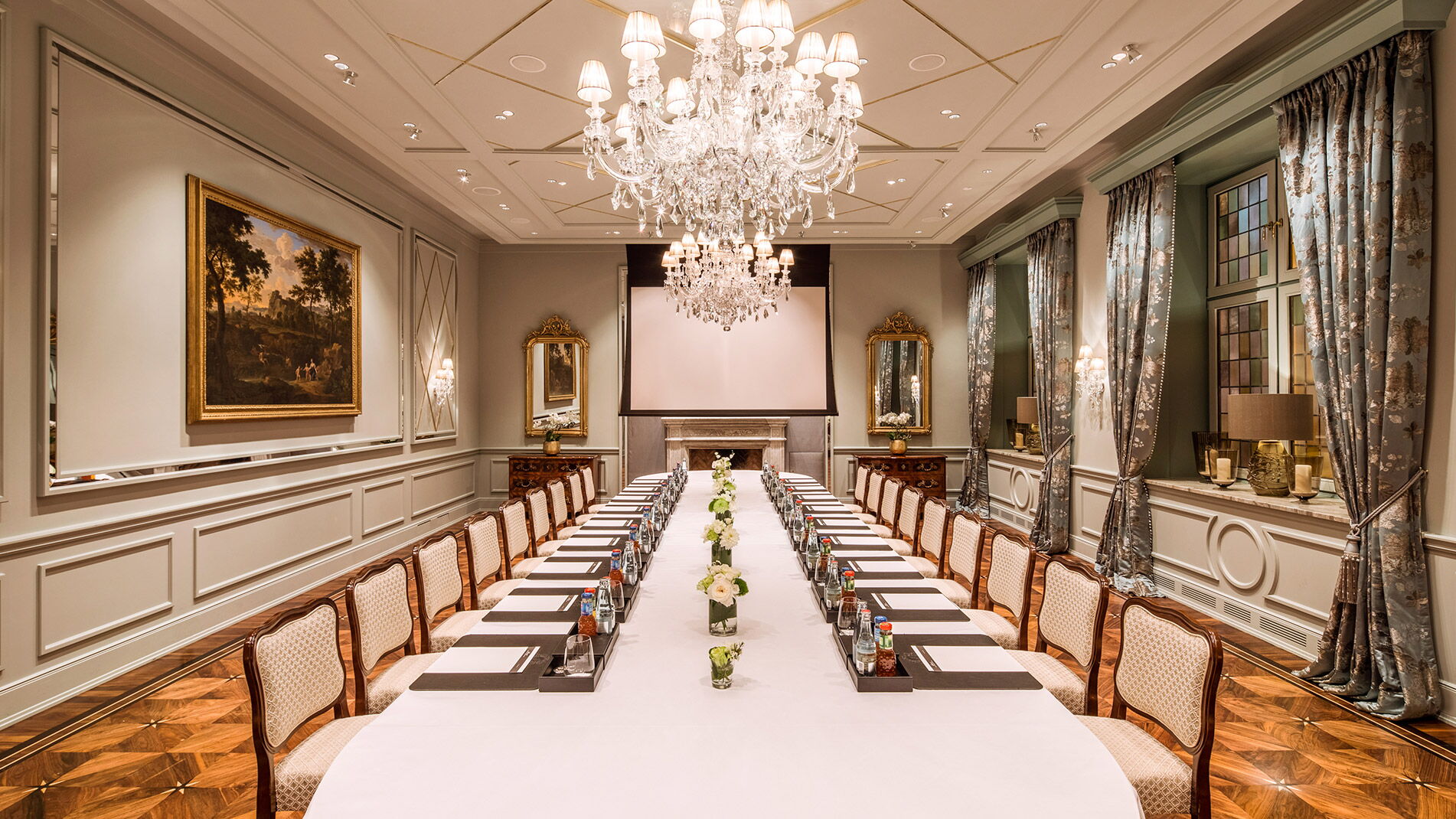 Eine lange gedeckte Tafel im stilvollen Raum mit Kronleuchter im Hotel Vier Jahreszeiten in Hamburg