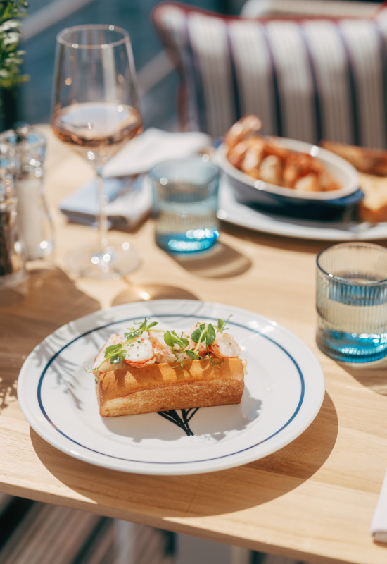 Golden brown roll with seafood and garnish on an atmospheric table setting