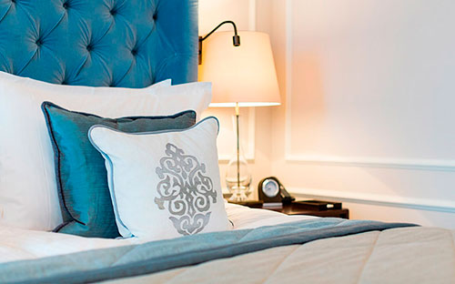 Nahaufnahme von weißen und türkisen Kissen auf einem Bett im Luxushotel in Hamburg